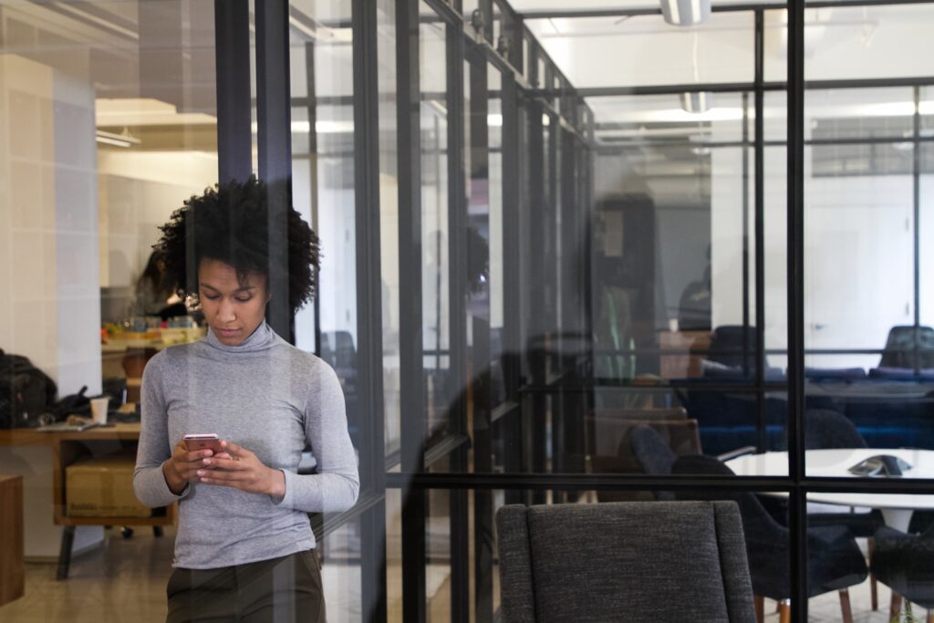 Lady Standing In The Office Checking Her Phone