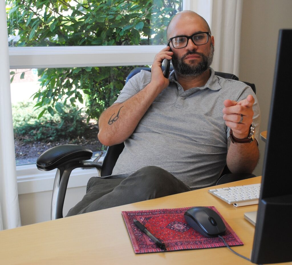 Man Talking On The Phone Sitting At Desk