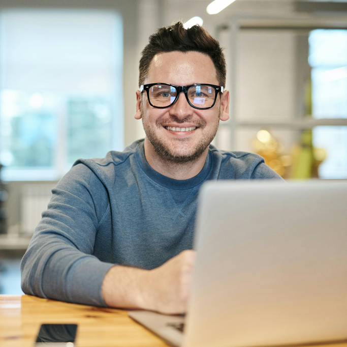 White Guy Working On Laptop Smiling