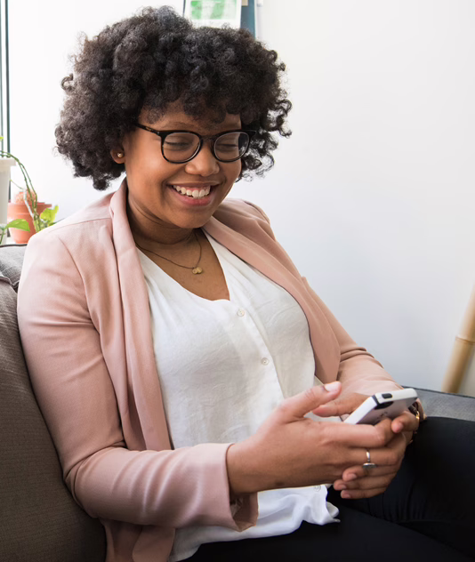 MWD Beautiful Black Lady Seated On Sofa Scrolling Her Phone