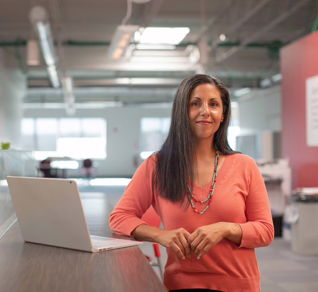 MWD - White Lady In A Red Blouse Standing by Her Elevated Desk