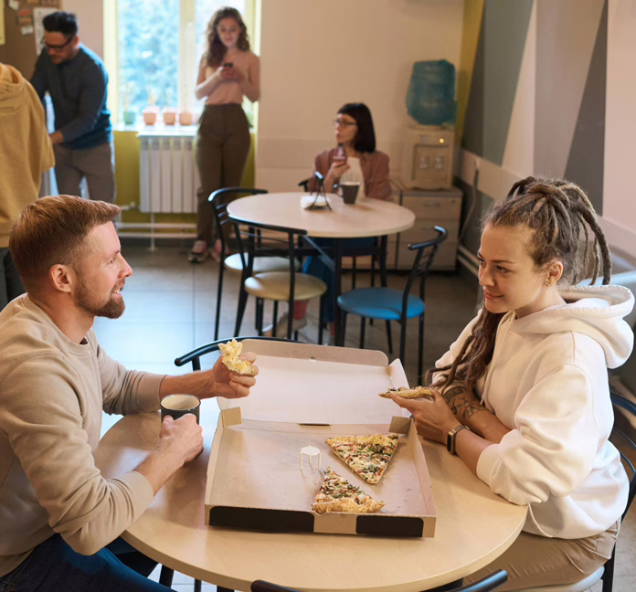 MWD - Un homme et une femme mangeant une pizza dans un restaurant