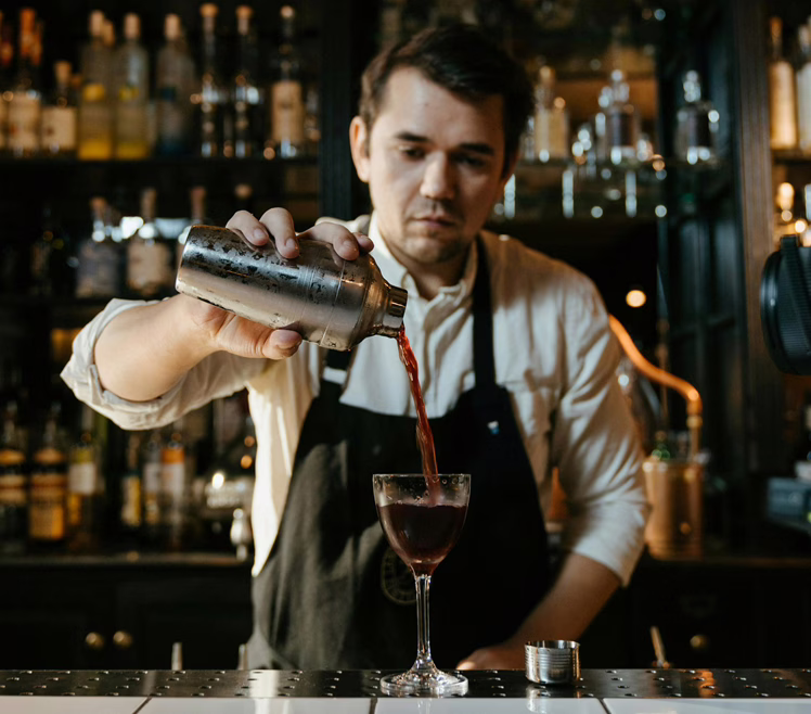 Un homme blanc servant des boissons dans un bar