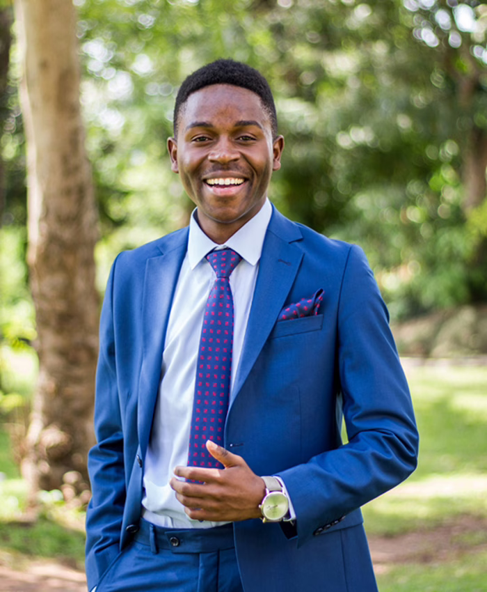 Jeune homme noir en costume bleu souriant