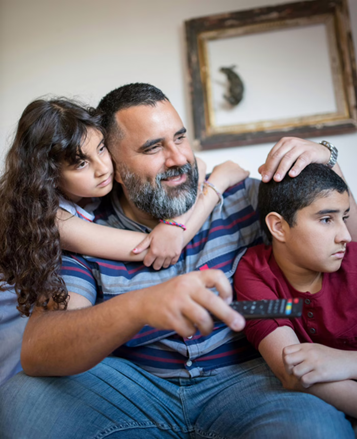 Père regardant la télévision avec ses deux enfants