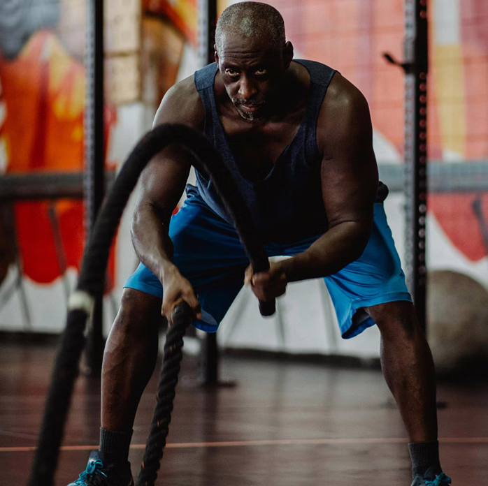 Entrenamiento de un hombre negro mayor en un gimnasio