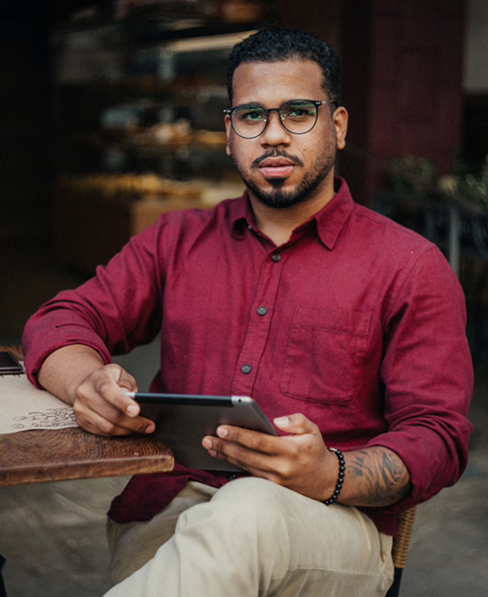 Hombre sosteniendo una tableta sentado en una mesa